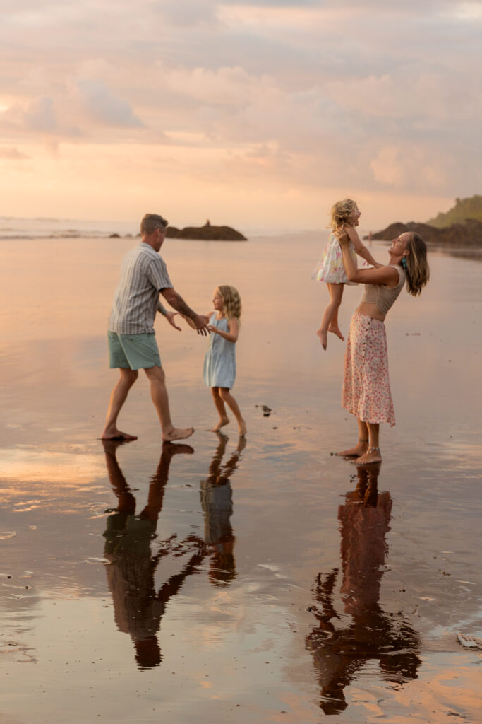 family of 4 playing on the beach in dominical costa rica